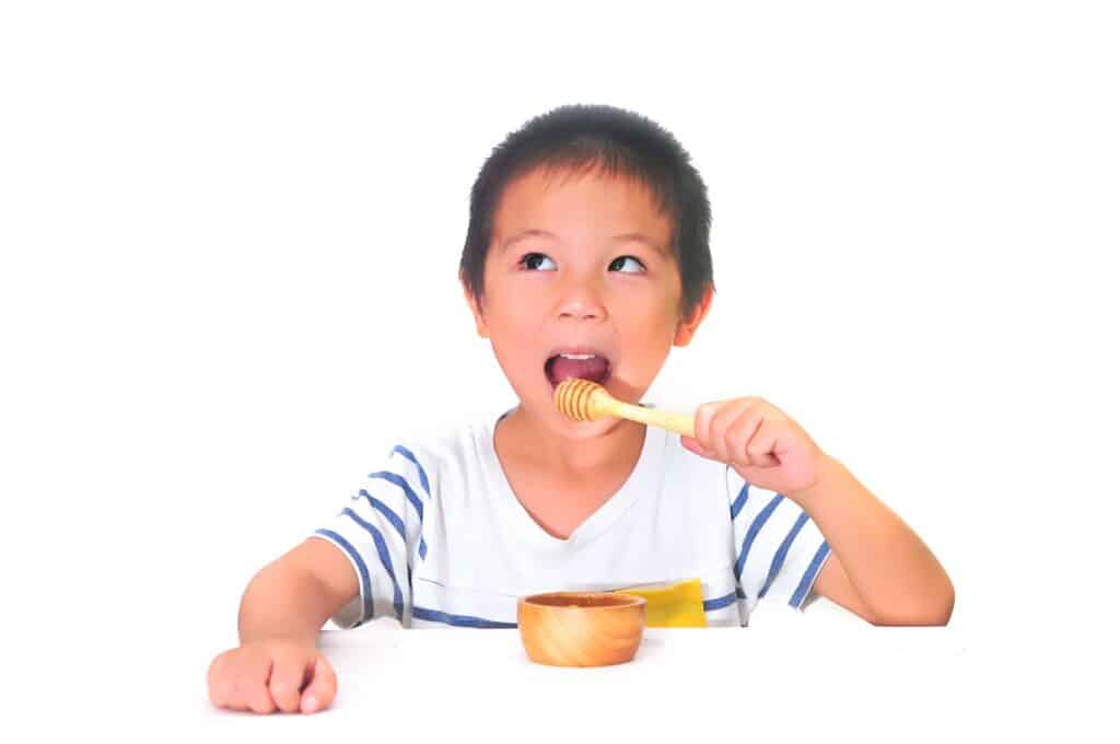 kid eating honey